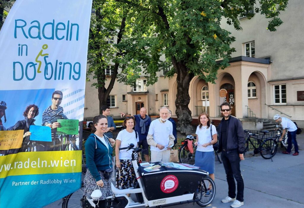 Fünf Mitglieder der Initiative stehen hinter einem Lastenrad neben einem Schild mit der Aufschrift "Radeln in Döbling"