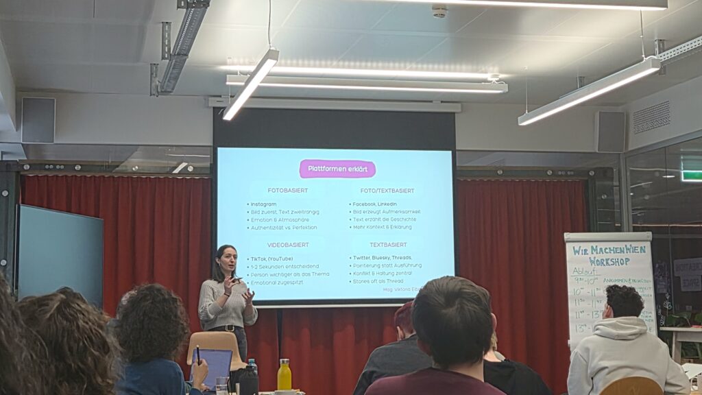 Viktoria Eibensteiner steht vor den Workshopteilnehmenden und erklärt die Merkmale der verschiedenen Social Media Plattformen.